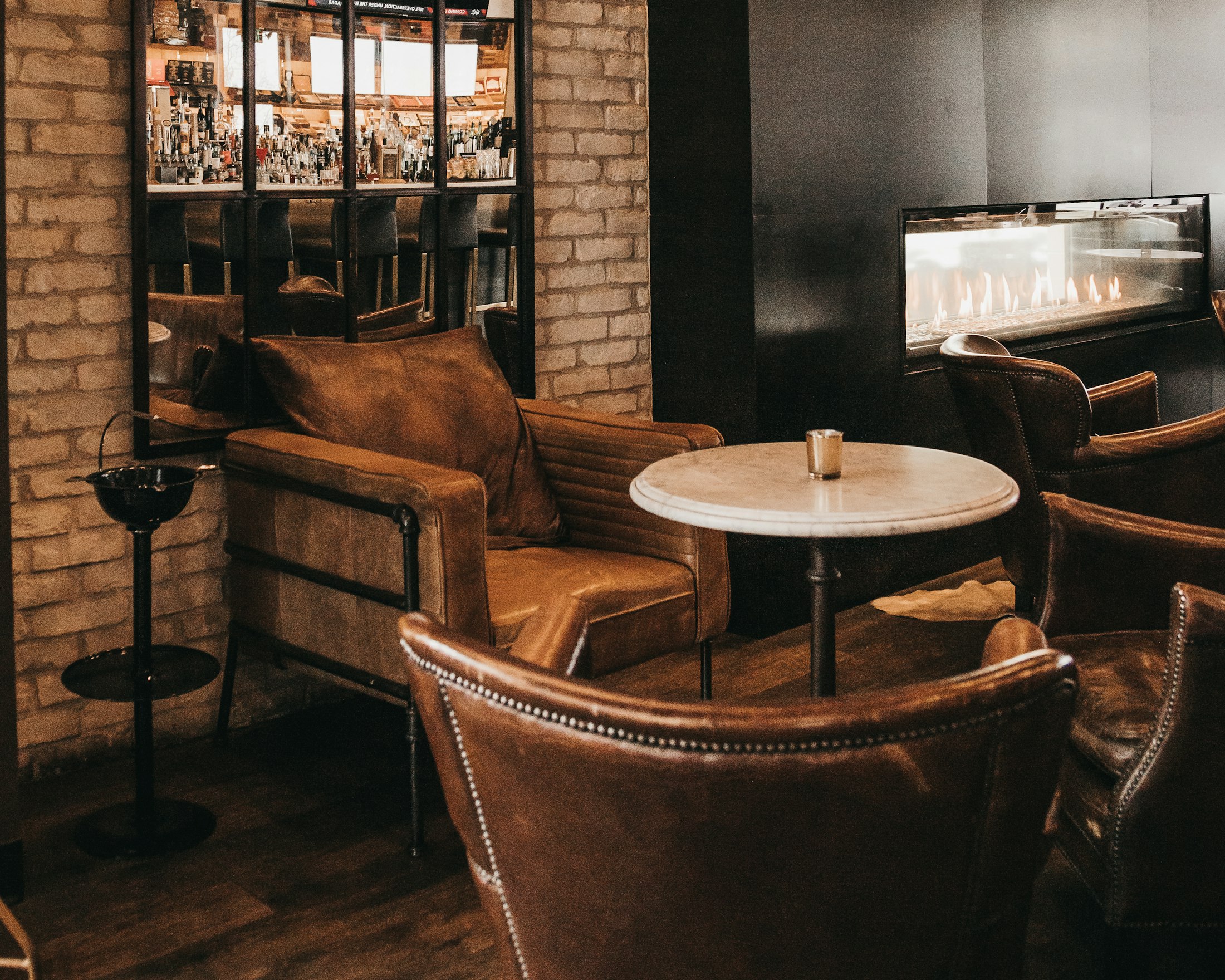 Leather lounge chairs against a painted brick wall