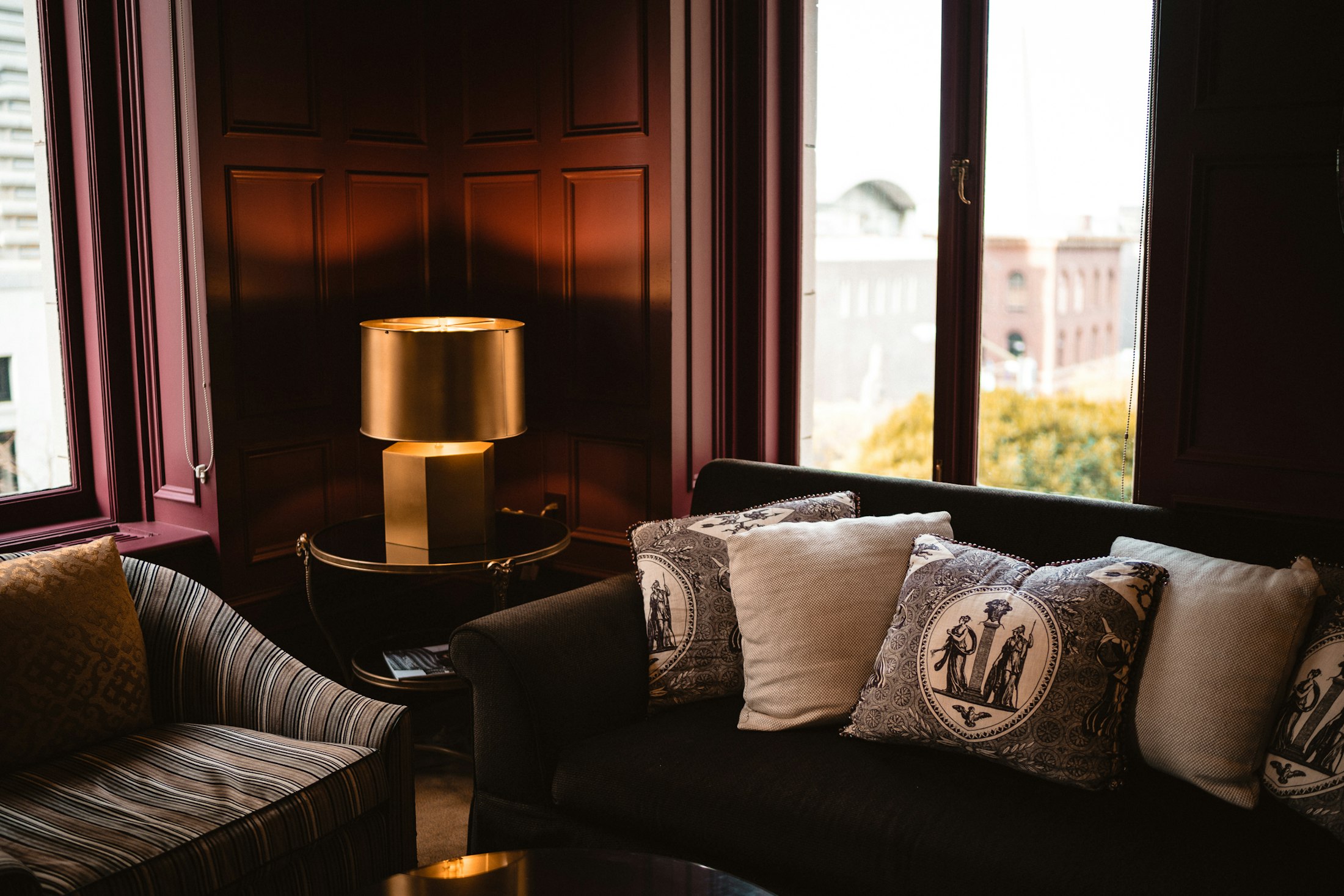 Dark panelled room with a brass table lamp
